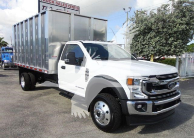 Ford F-550 dump truck in white cab with silver dump bed, front view slightly angled, stock number F5504X4CHIPPER.