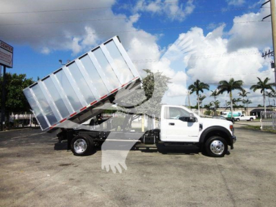 Dump truck in service with elevated cargo bed on Ford F-550 chassis showing dump truck configuration.