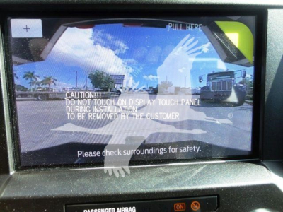 Dashboard display screen showing caution message and touch panel in Ford F-550 dump truck interior.
