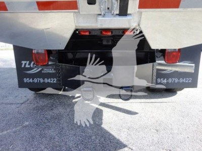 Ford F550 dump truck rear view showing bumper area, taillights, and hitch with TCL truck equipment label and phone numbers