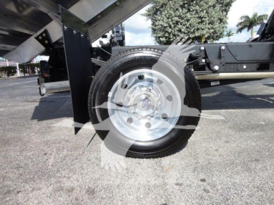 Ford F550 dump truck wheel and semi-trailer hitch area showing polished steel rim and tire.