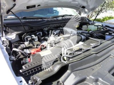 Ford F-550 engine bay view with hood open showing air intake, engine components, and coolant reservoir.