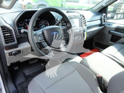 Ford F-550 interior front cabin showing steering wheel, instrument cluster, center console, and front seats.