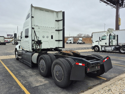 Truck tractor chassis with fifth wheel and rear mud flaps; no cab interior visible.