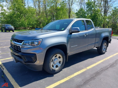 Chevrolet Colorado extended cab pickup truck parked in a lot showing the driver side with metallic gray color and chrome grille.