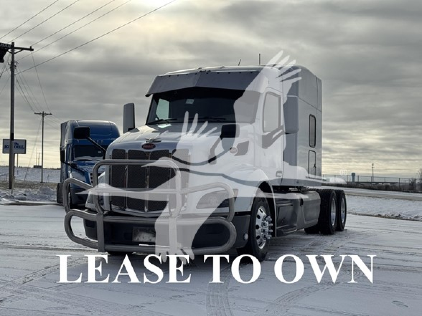Peterbilt 579 tractor-trailer in a snow-covered lot with 'LEASE TO OWN' watermark.