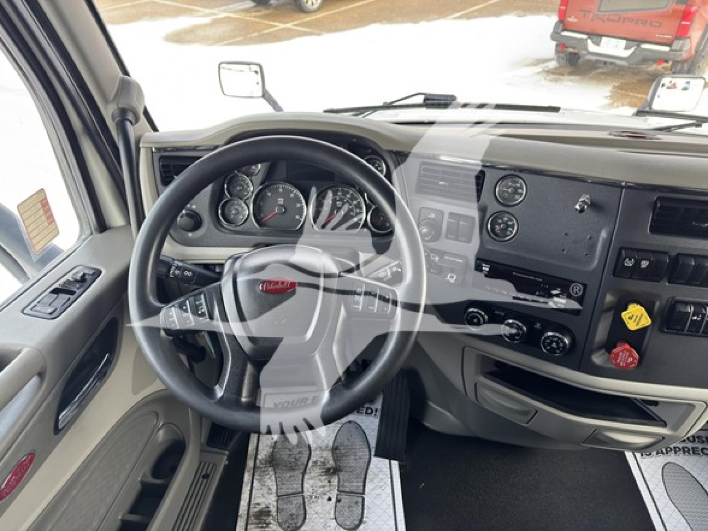 Peterbilt dashboard and steering wheel interior view showing instrument cluster and center console with multiple controls.