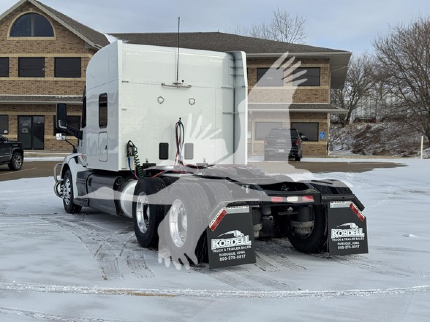 Peterbilt 579 trunk area rear view showing sleeper cab and dual rear axles in snow.