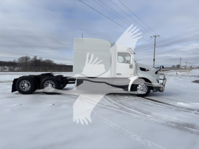 2019 Peterbilt 579 conventional sleeper truck in a snowy lot, side view showing cab and rear tractor wheels; no visible labels or stickers legible on image.