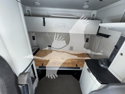Truck cab interior with sleeper area and storage cabinets visible. Text on rear panel reads 'EQUIPMENT' or generic manufacturer label, no other legible text visible.