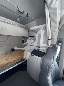 Peterbilt 579 truck sleeper cabin interior showing storage shelves and seating area.