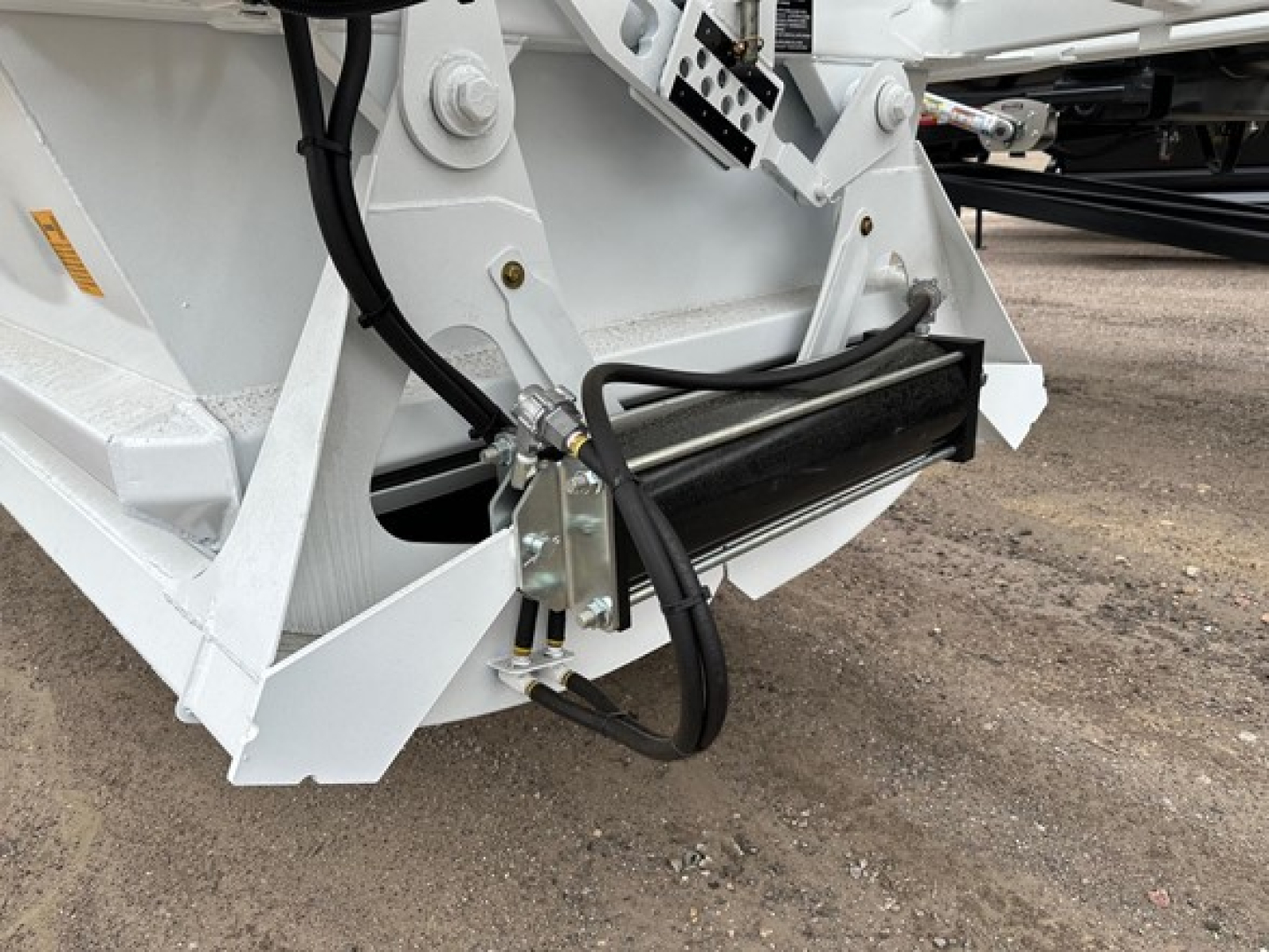 Ranco LW21-40 dump trailer component showing hydraulic hoses, metal frame, and mounting bracket with hydraulic cylinder.