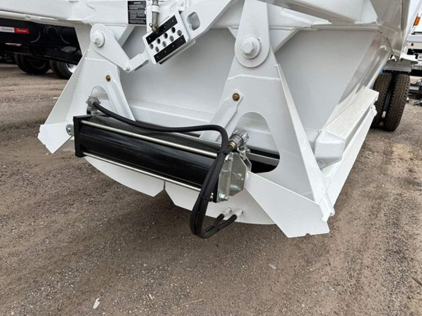 Ranco LW21-40 trailer component showing hydraulic hose assembly and white metal chassis with black hydraulic cylinder near bottom.