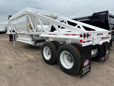 Ranco LW21-40 dump trailer showing dual axles and white frame with diamond plate fenders and rear lighting