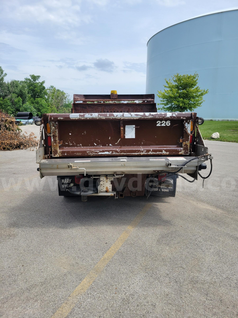 Rear view of a brown dump bed plow truck with 226 on tailgate, Henderson-style heavy-duty dump bed, in-service condition.