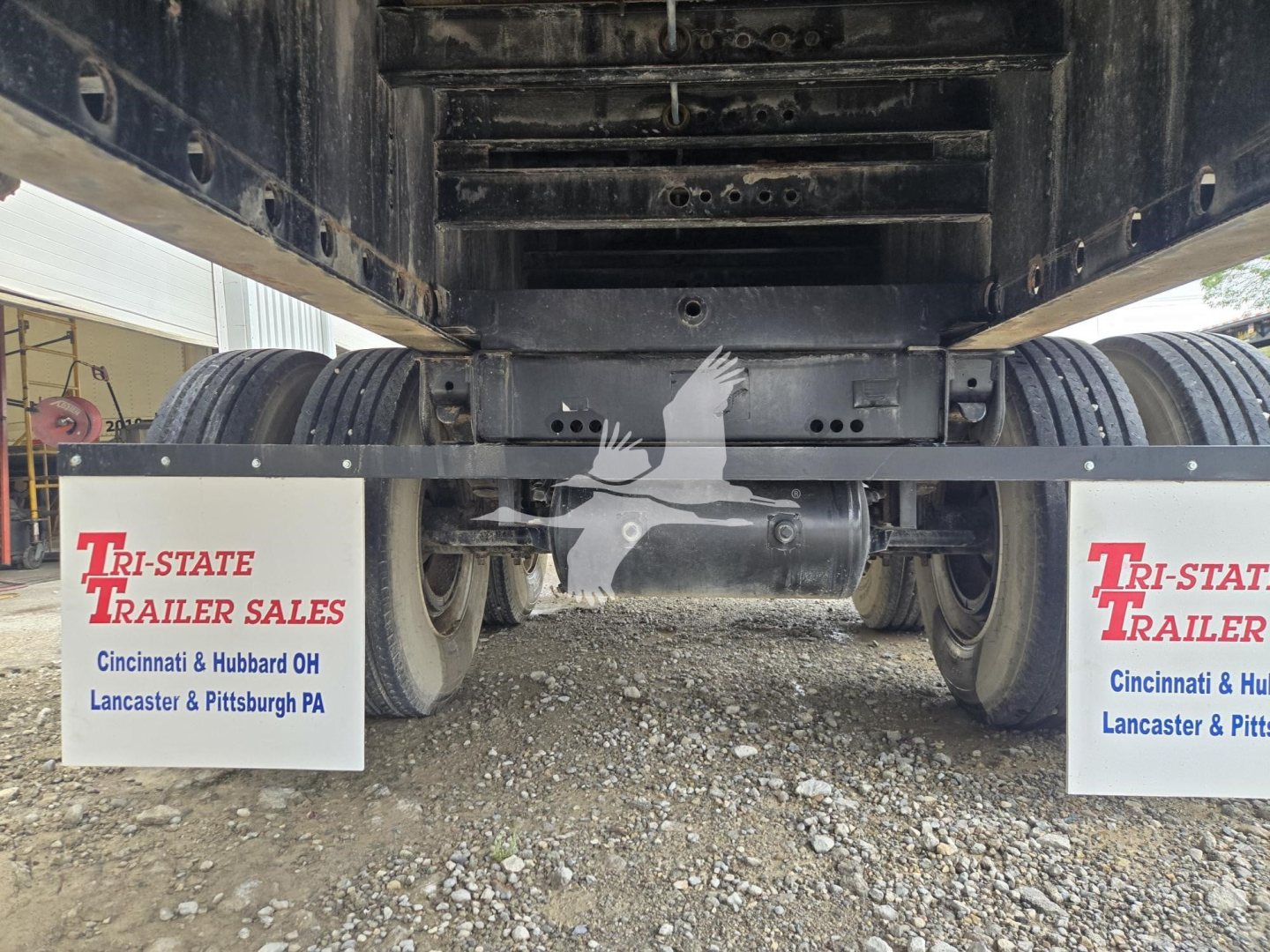 Trailer underside showing wheels and mudflaps with Tri-State Trailer Sales logo and text, and VIN/Stock details above.