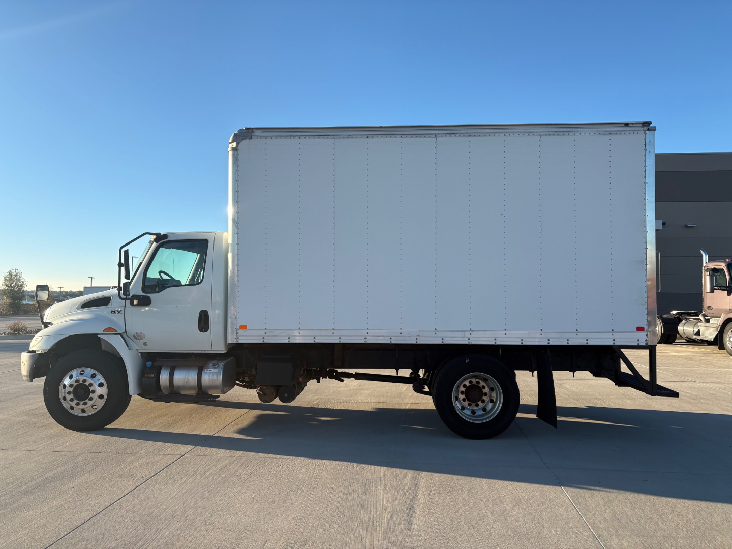 Box truck side view with white cargo box and cab showing clean exterior, no visible text or branding.