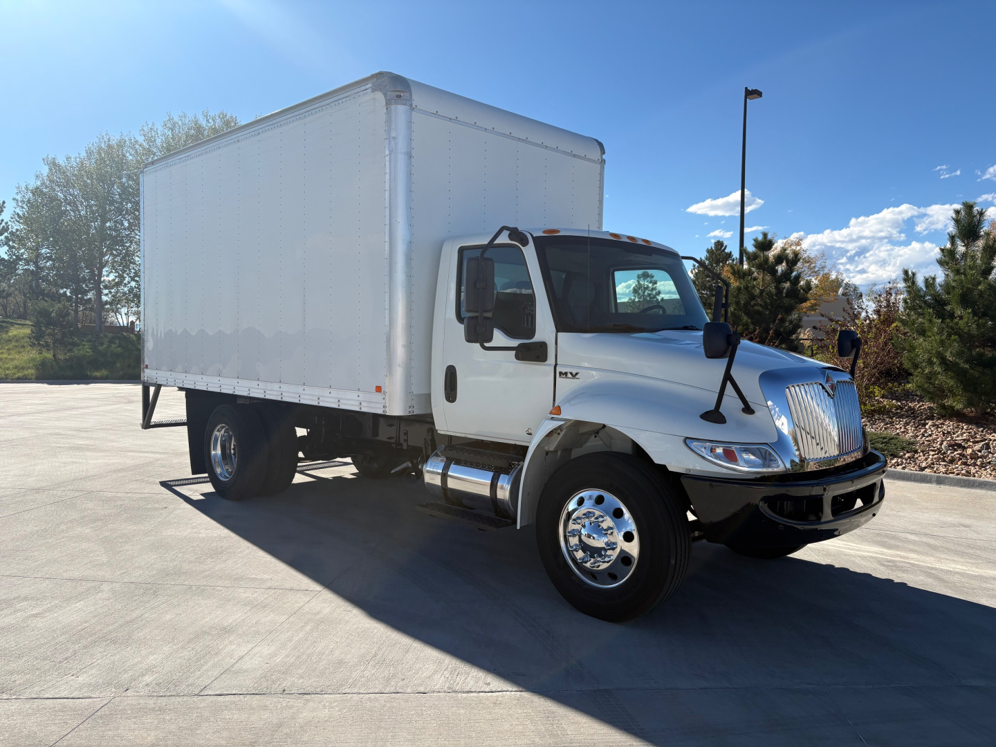 Box truck 2021 International MV607 side/front view showing cab and cargo box. VIN 3HAEUMML4ML389414 visible in listing data.