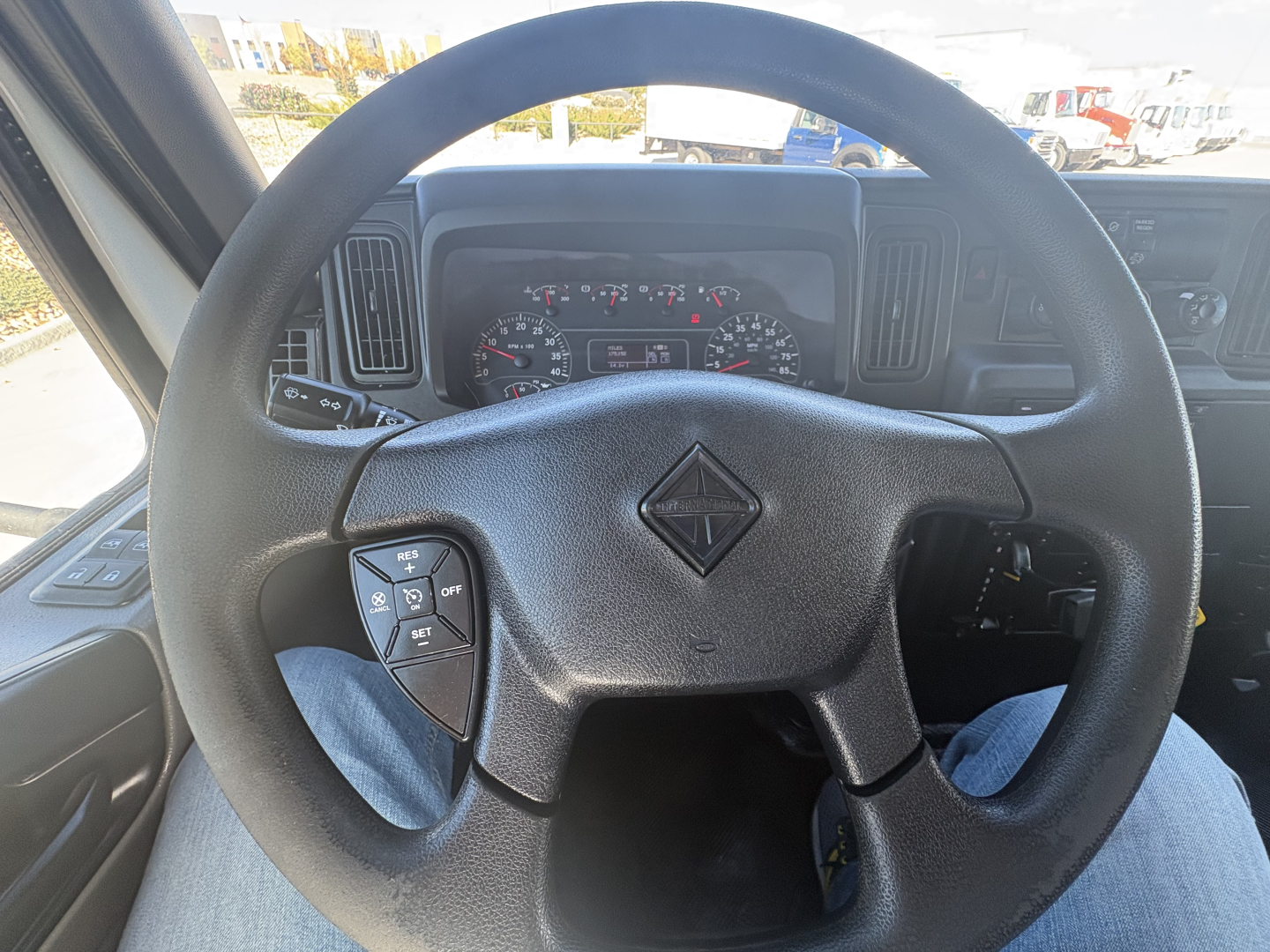 Steering wheel and dashboard of a 2021 International MV607 truck showing instrument cluster and controls.