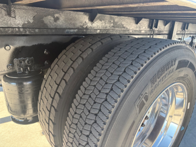 Truck wheel area showing dual rear tires with RimTek or similar brand tyres, electric filter canister and undercarriage frame. Visible text on tire reads 'HTR...' (not fully legible).