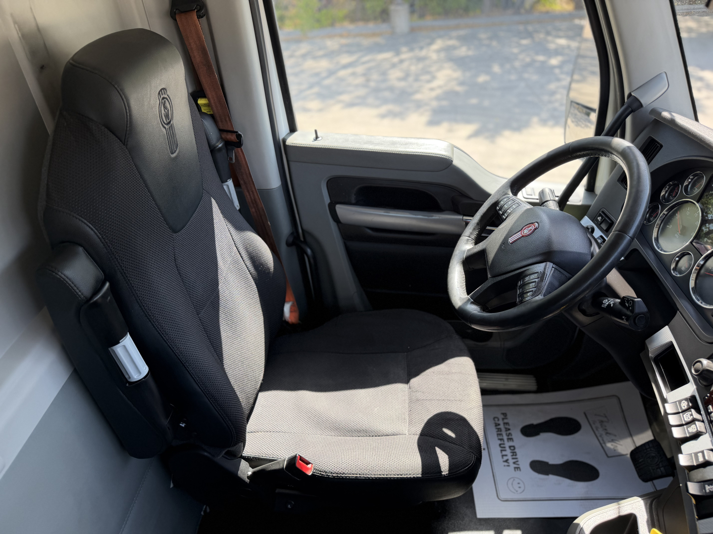 Kenworth T680 truck interior showing driver's seat and dashboard area with steering wheel.