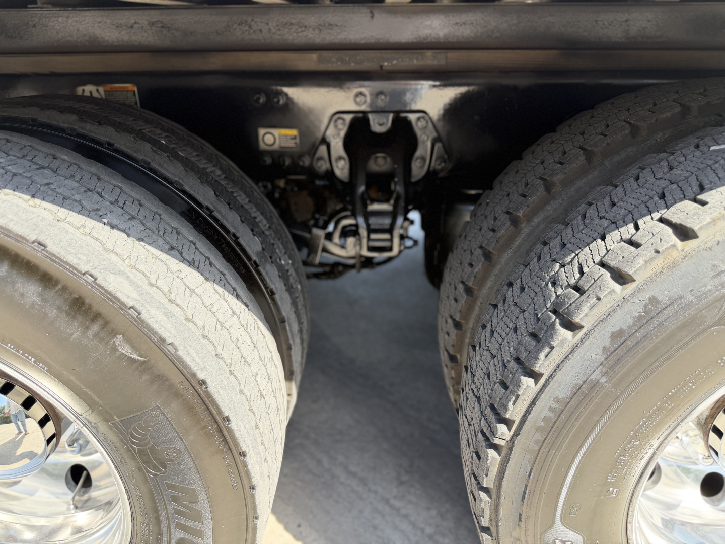 Kenworth T680 rear underside showing dual rear axles, suspension components, and air lines.