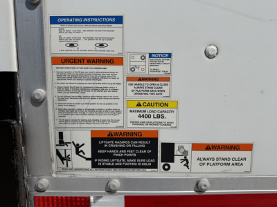 Panel of operating instructions and warnings on a Kenworth T680 truck side showing multiple labels including urgent warning and caution signs.