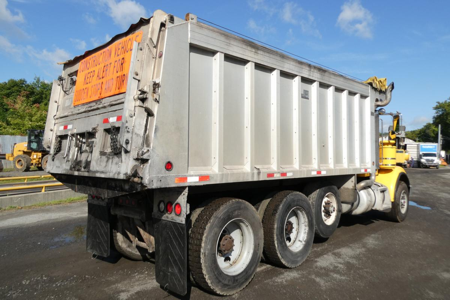 Peterbilt 357 dump truck rear and side view showing aluminum dump body and dual rear wheels.