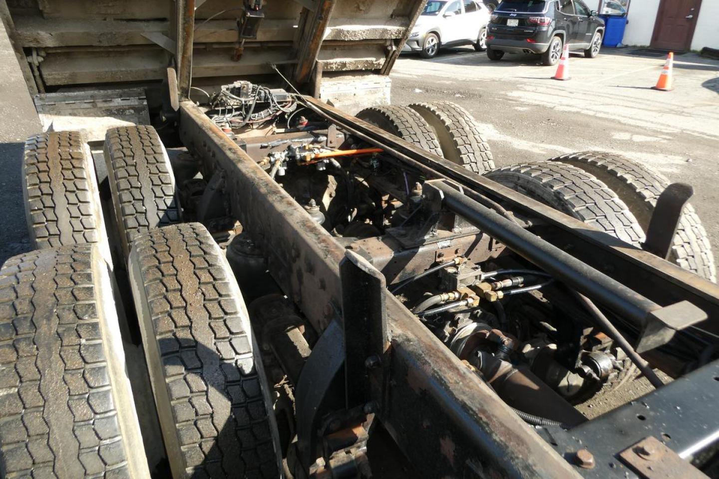 _dump truck chassis showing rear dual axles and frame rails with drivetrain components visible under the dump bed