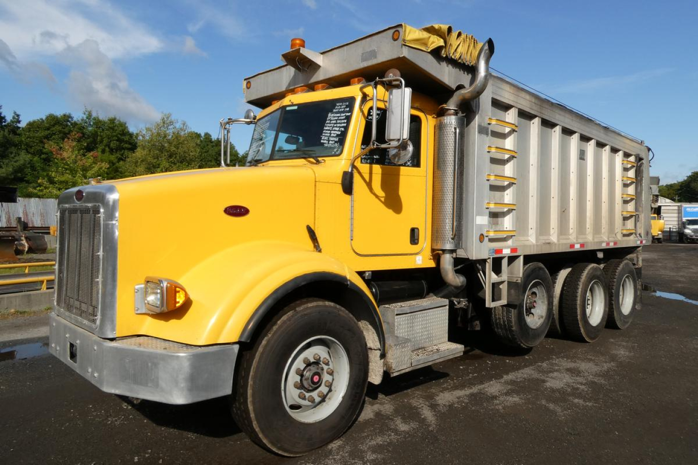 Yellow Peterbilt 357 dump truck with oversized dump bed and side rails, front grille, single exhaust, and 6-wheel configuration.
