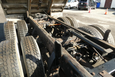 _dump truck chassis showing rear dual axles and frame rails with drivetrain components visible under the dump bed
