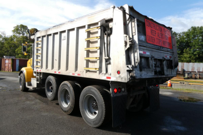 Peterbilt 357 dump truck rear and side view showing dump bed and dual rear axles.