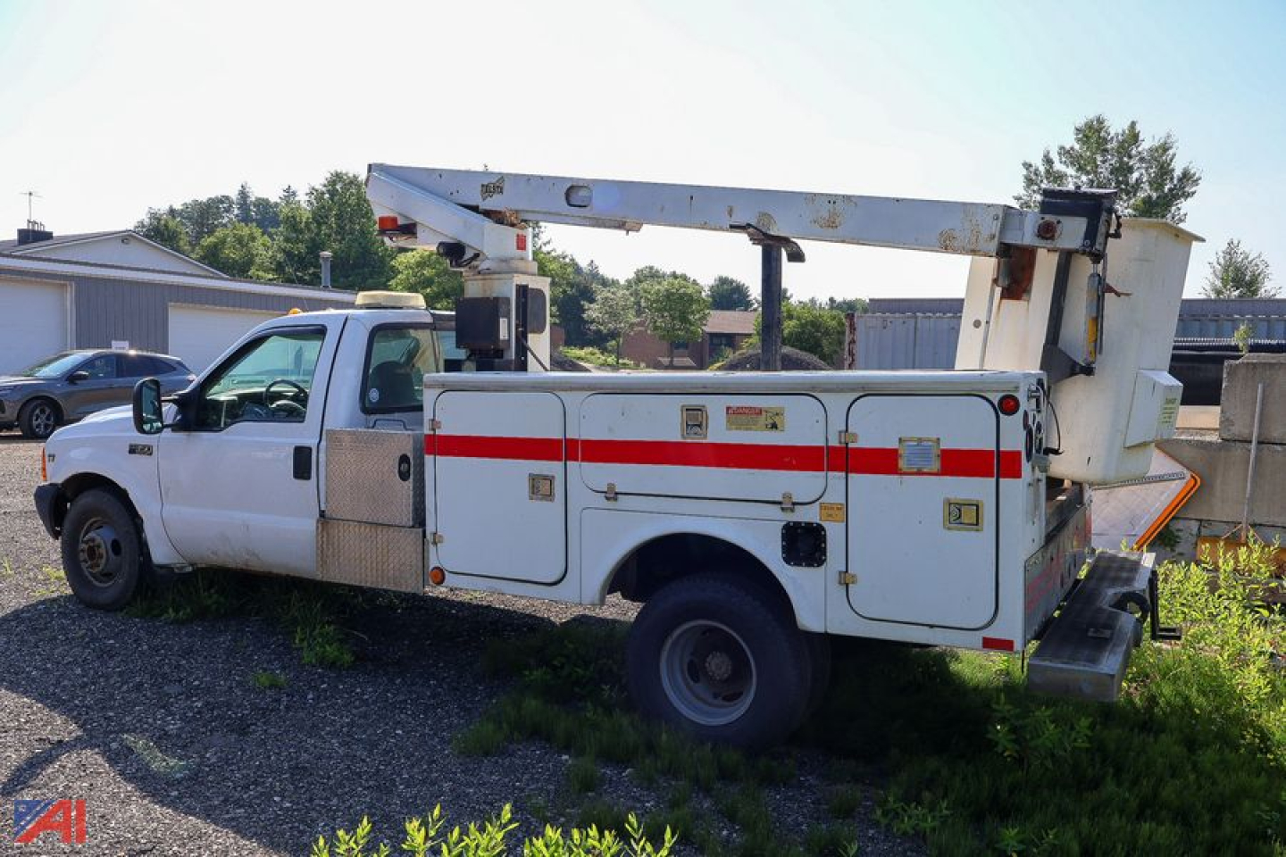 1999 Ford F-350 Super Duty Telsta bucket truck in-service side view showing utility compartments and bucket lift arm