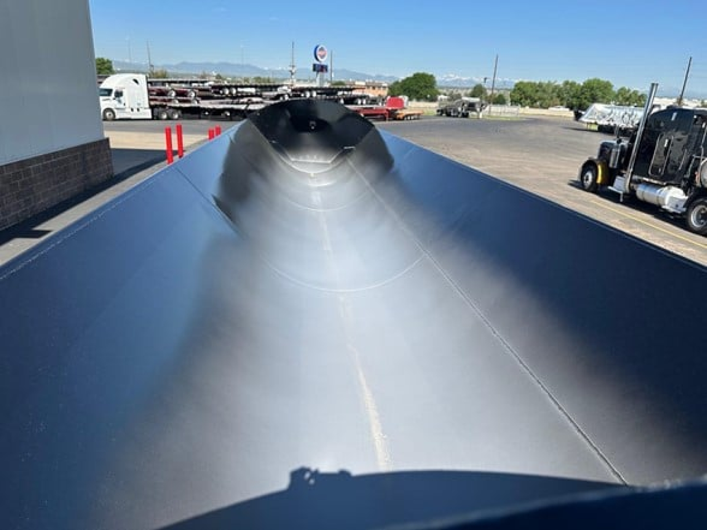 Trailer top view showing smooth silver surface and cone-shaped apex of a Jet Side Dump trailer.