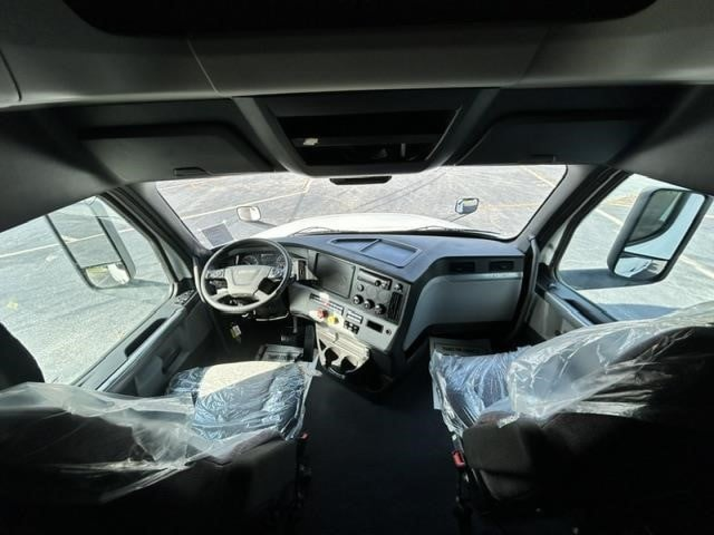 Cab interior of a Freightliner Cascadia 126 truck showing dashboard and steering wheel.
