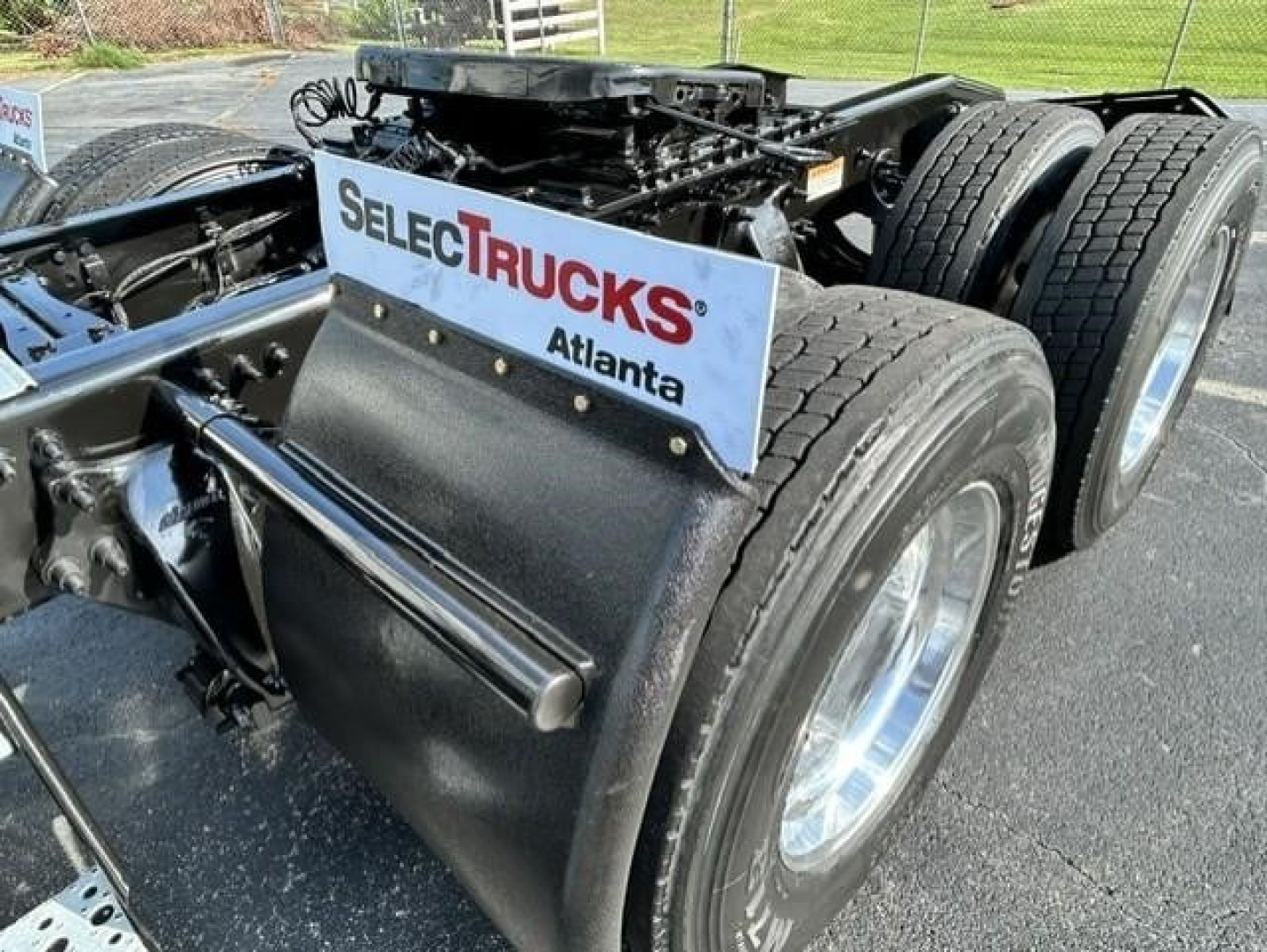 Freightliner Cascadia 126 chassis rear wheels and fifth wheel area with dual rear axles and a front-fender mudguard; sticker reads SEL ECTR UCKS Atlanta.