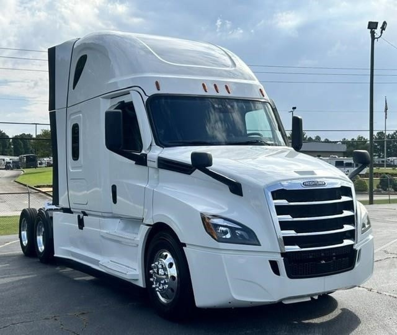 Freightliner Cascadia 126 tractor-trailer cab shown from front-right angle with white exterior and chrome grille.
