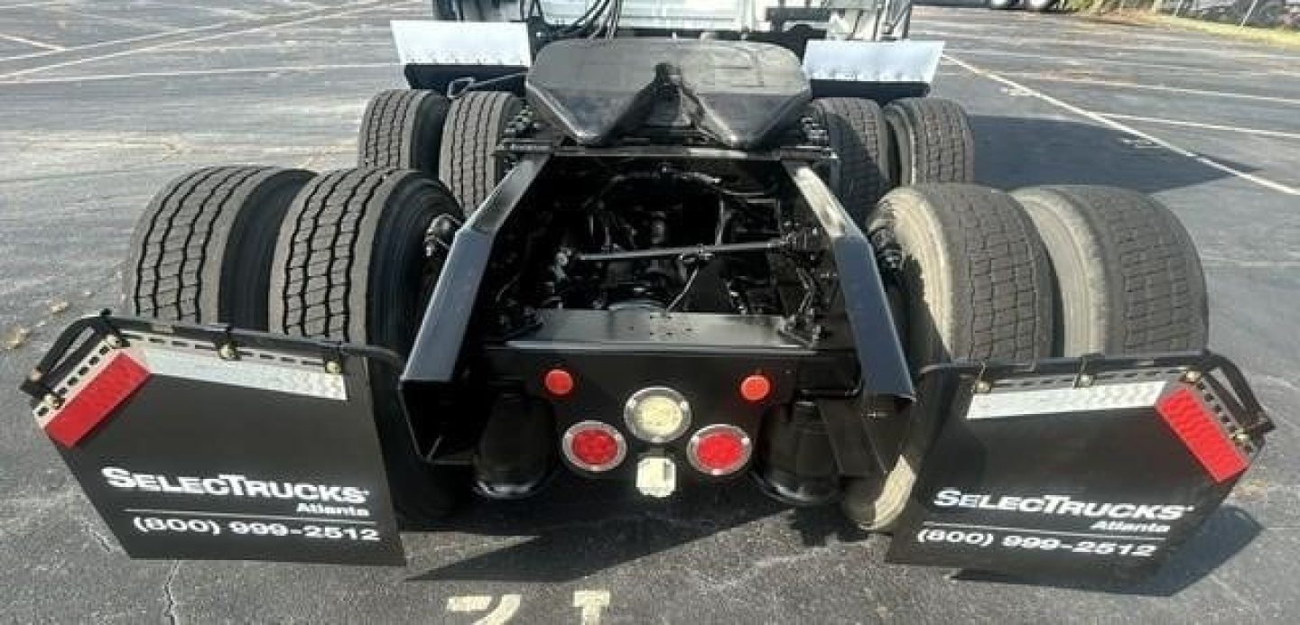 Rear view of a 2021 Freightliner Cascadia 126 tractor showing dual rear axle configuration, mud flaps with 'SELECTTRUCKS' branding, and center equipment area.
