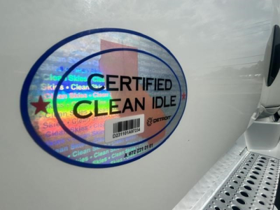 Sticker on Freightliner truck showing 'CERTIFIED CLEAN IDLE' with holographic background and circular border. Part of cab door area.