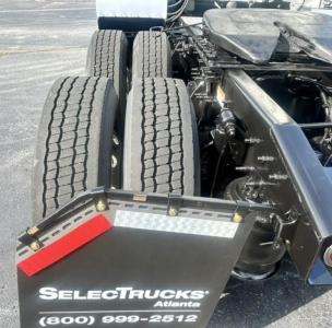 Freightliner Cascadia 126 drivetrain rear view showing dual rear axles and wheel wells with mudflap reading SelectTrucks Atlanta contact number.