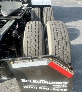 Rear view of Freightliner Cascadia 126 tractor showing tandem rear axles, dual tires, and a fender with Reflective strip and SELECTRUCKS Atlanta plate.