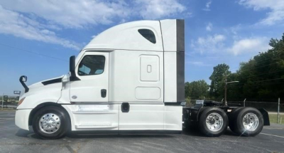 Freightliner Cascadia 126 tractor cab side view showing sleeper cab, white exterior, dual rear axles, chrome wheels, and aerodynamic design.