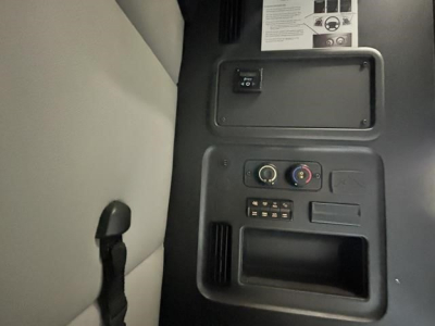 Cab interior panel of Freightliner Cascadia showing control dial gauges and storage cubby.