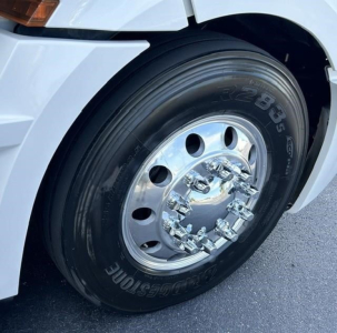 Freightliner Cascadia 126 front wheel showing Bridgestone tire and polished chrome hubcap.
