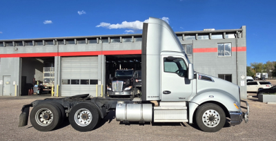 Kenworth T680 tractor in side view showing cab logo and chassis with dual rear axles and fuel tanks.