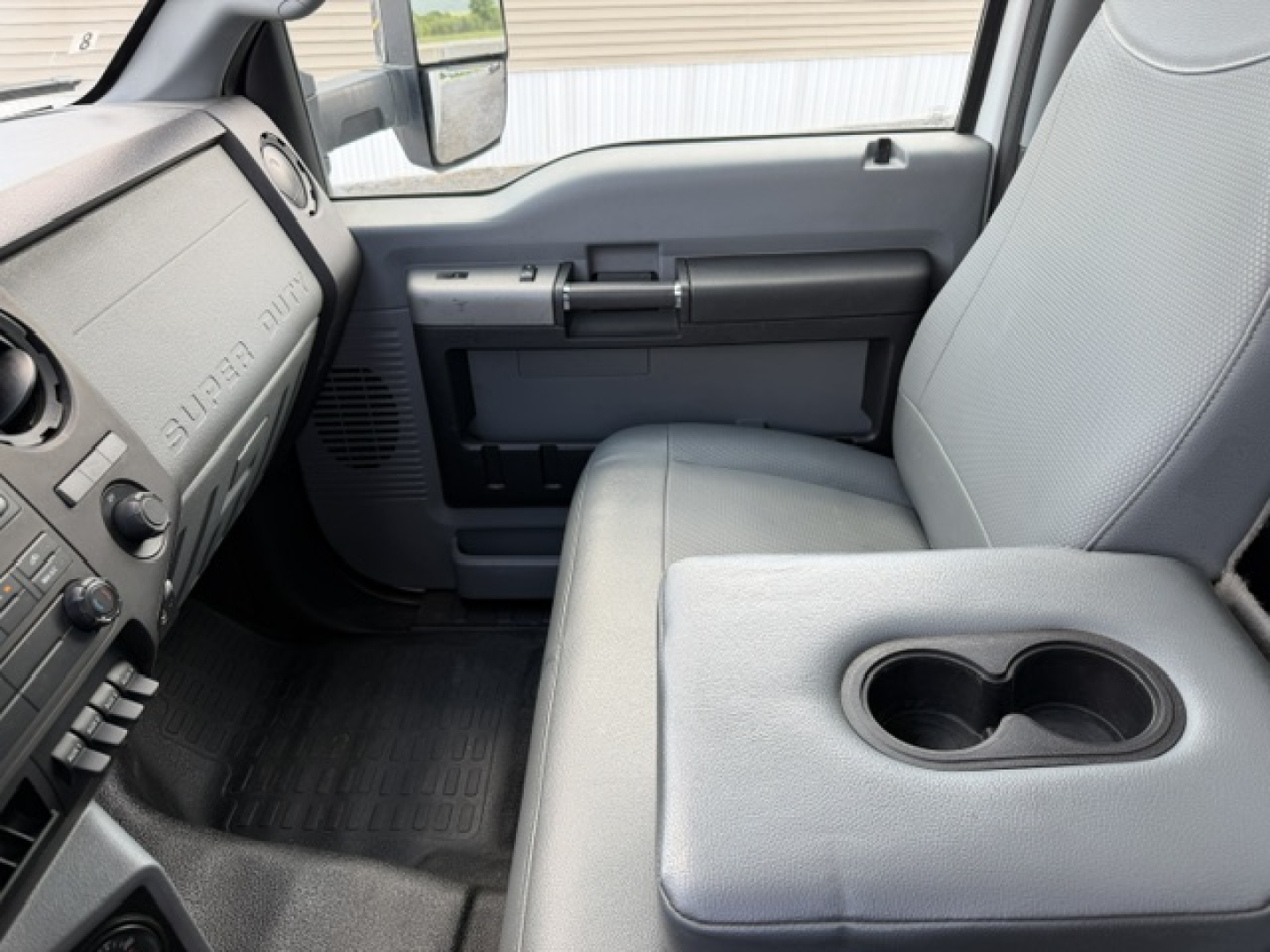 Ford F-750SD cab interior showing dashboard, driver door panel, and center console with cup holders.