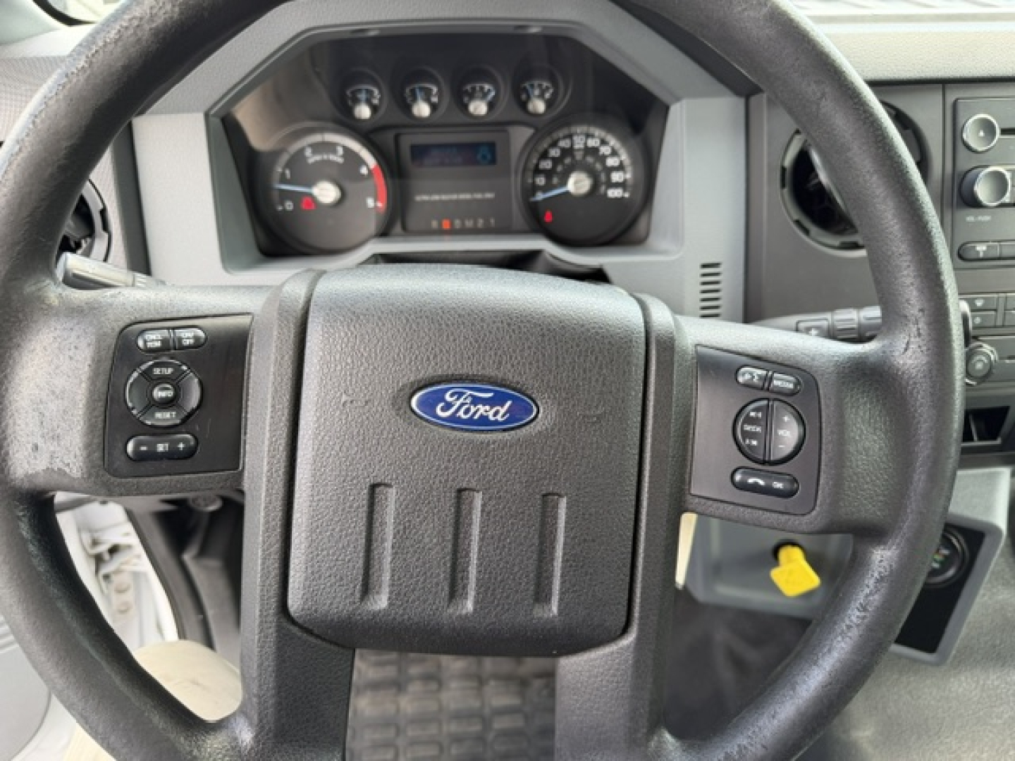 Ford steering wheel and instrument cluster in a 2016 Ford F-750SD cab showing steering wheel with Ford emblem and gauge cluster/