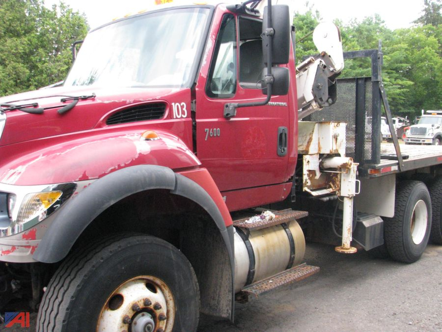 Truck cab side of 2006 International SF547 WorkStar 7600 flatbed with crane hoist and fuel tank visible.