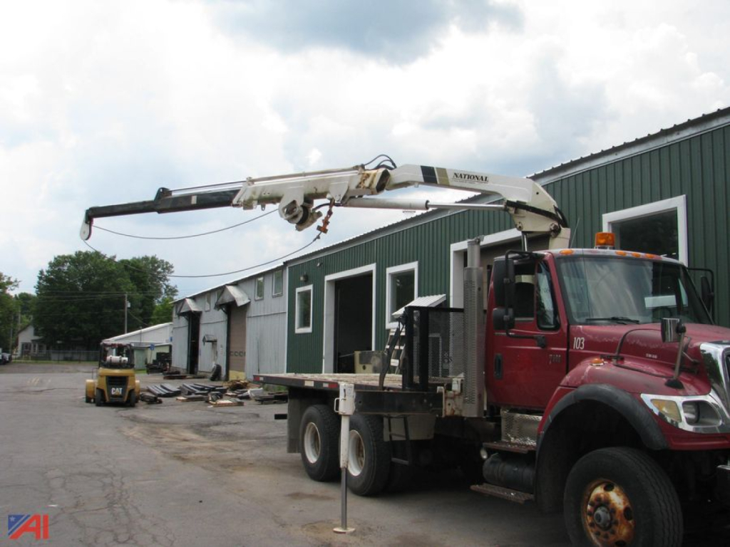 2006 International SF547 WorkStar flatbed tow truck with crane, red cab, in-service equipment on site