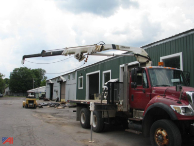 2006 International SF547 WorkStar flatbed tow truck with crane, red cab, in-service equipment on site